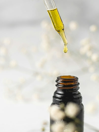 Cannabis oil dripping into a brown glass jar